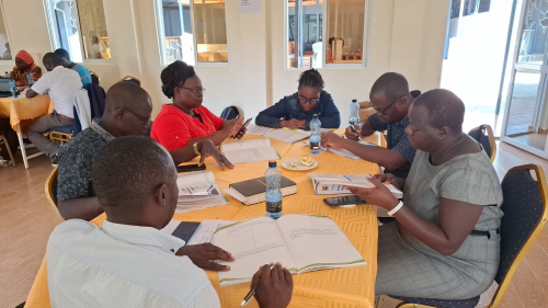 From right-HIV cordinator Silvia Imbuye and other health stakeholders going through the intergration service delivery manual for prevention, management and treatment of HIV, STDs and Viral Hepatitis.PHOTO/Eric Juma